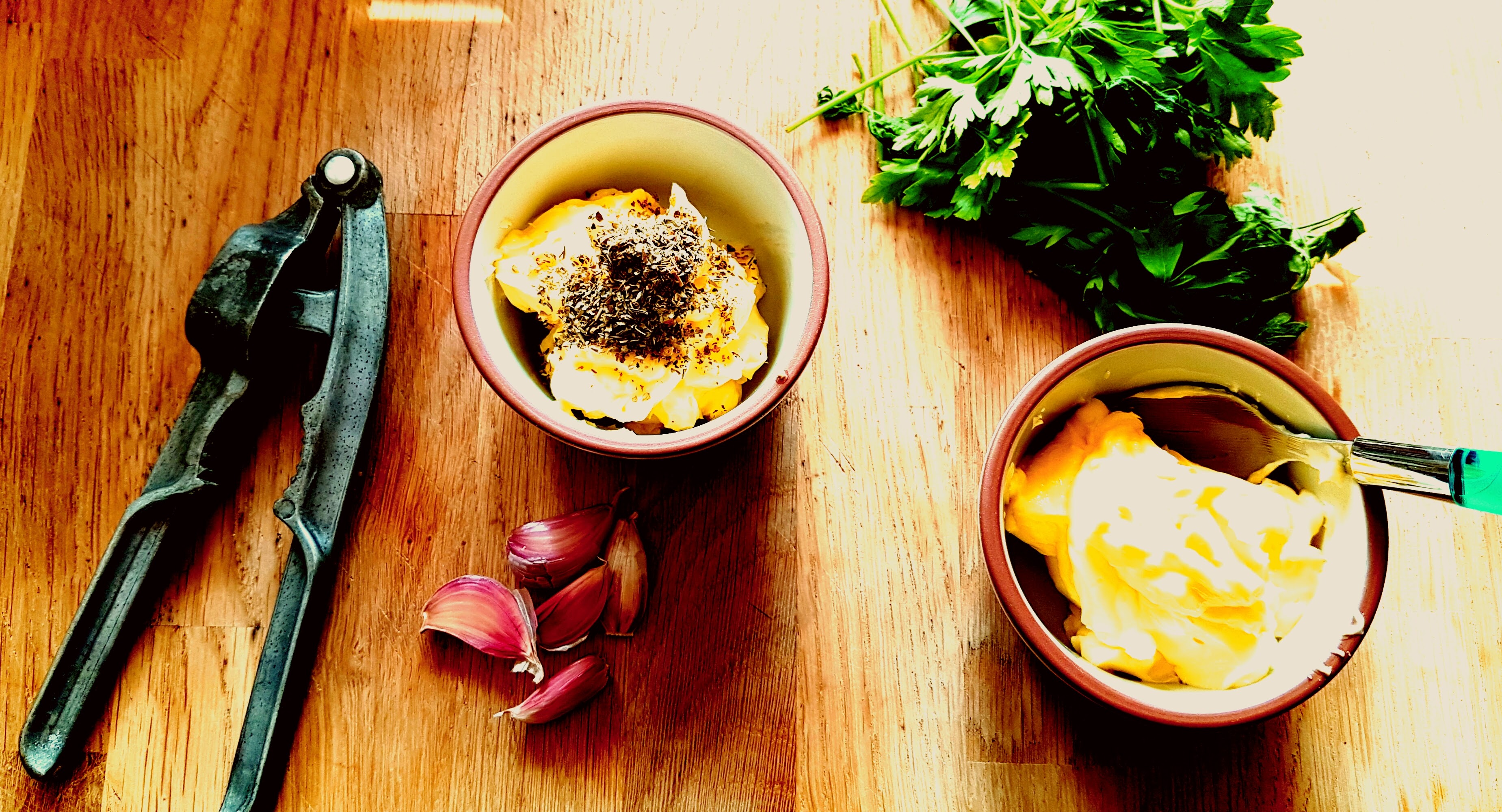 Herbs, garlic and ingredients on a wooden kitchen table