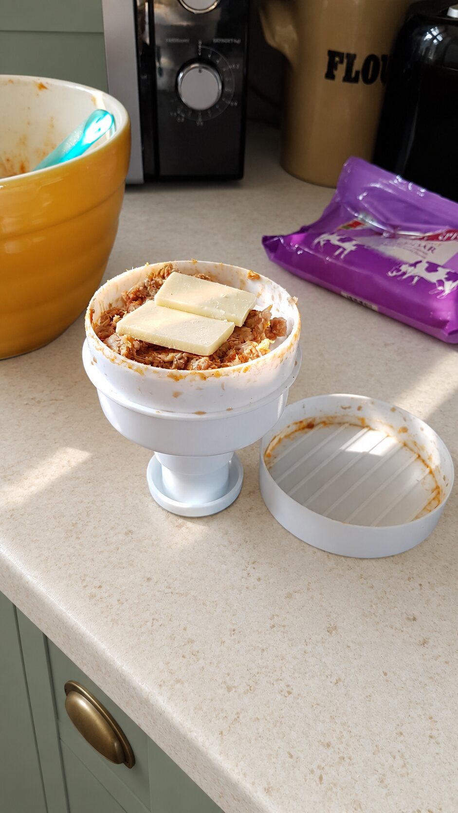 Homemade burger mixture and cheese layered inside a burger press