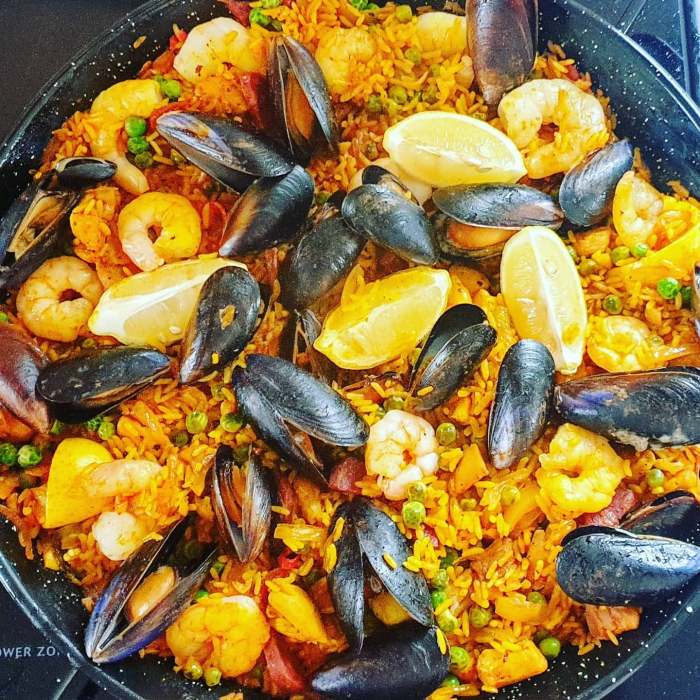 Chicken, chorizo and seafood paella with prawns, mussels, peas and charred lemon