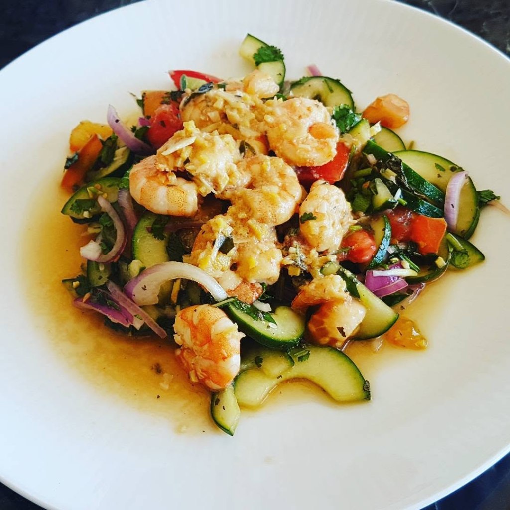 Thai-style prawn salad with cucumber, tomatoes, red onion, fresh herbs and a spicy lime dressing